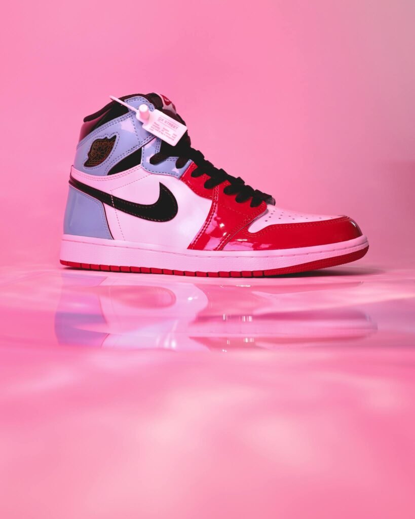 High-top sneaker showcased on a reflective pink backdrop emphasizing stylish modern design.